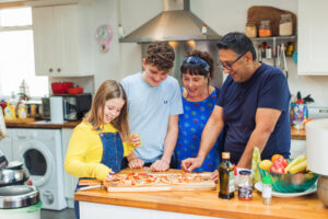 Family in kitchen with pizza