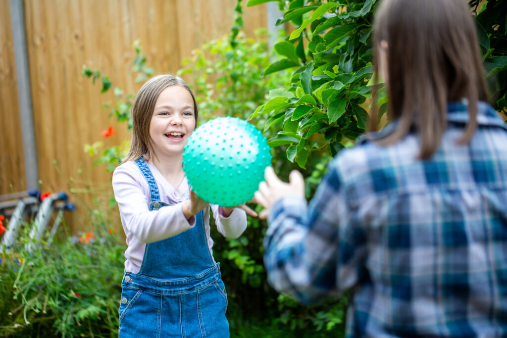 Two girls playing with a ball in the garden